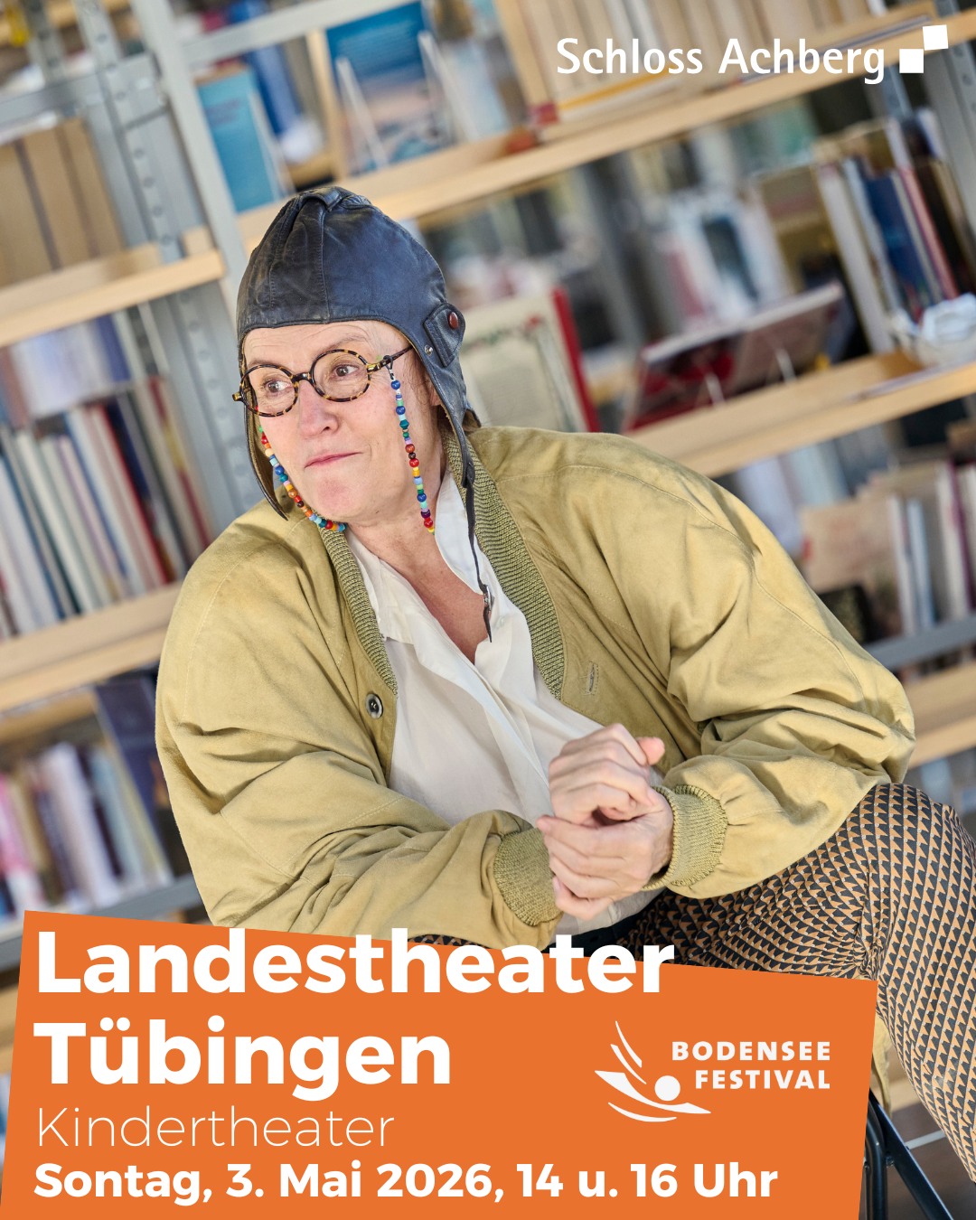 Dieser Alternativtext wurde KI-generiert: Ein Schwarz-Weiß-Foto zeigt eine Person, die lächelt und in die Kamera schaut. Im Hintergrund befindet sich ein Bücherregal und Text, der Informationen zu einer Veranstaltung enthält.