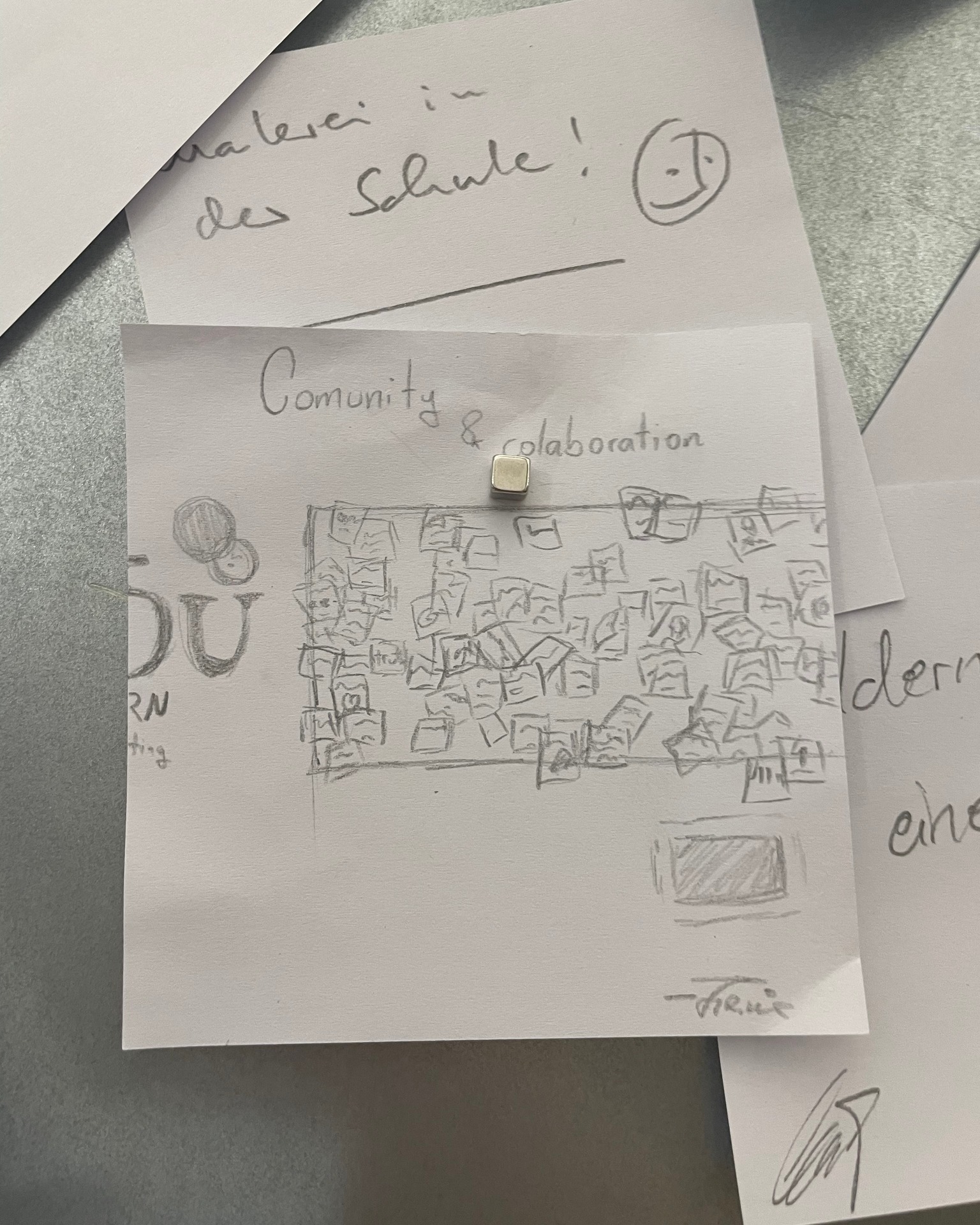 Dieser Alternativtext wurde KI-generiert: Schwarz-weißes Foto von handgezeichneten Skizzen, die an einer Wand befestigt sind. Die Zeichnungen zeigen Stadtansichten und Textfragmente, arrangiert auf Papierblättern.