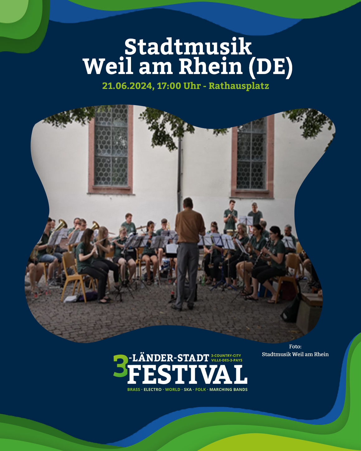  Das Bild zeigt eine Blaskapelle, die auf einem Platz vor einem Gebäude spielt. Im Hintergrund sind Zuschauer zu sehen.