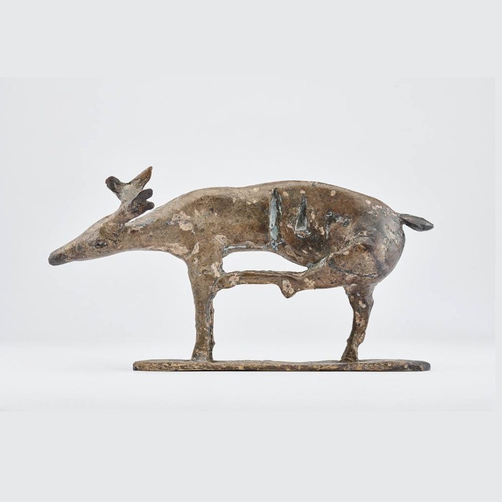 Dieser Alternativtext wurde KI-generiert: Eine Skulptur eines vierbeinigen Tieres aus metallischem Material ist auf einer Basis zu sehen. Das Bild ist in Farbtönen von Braun und Grau gehalten.