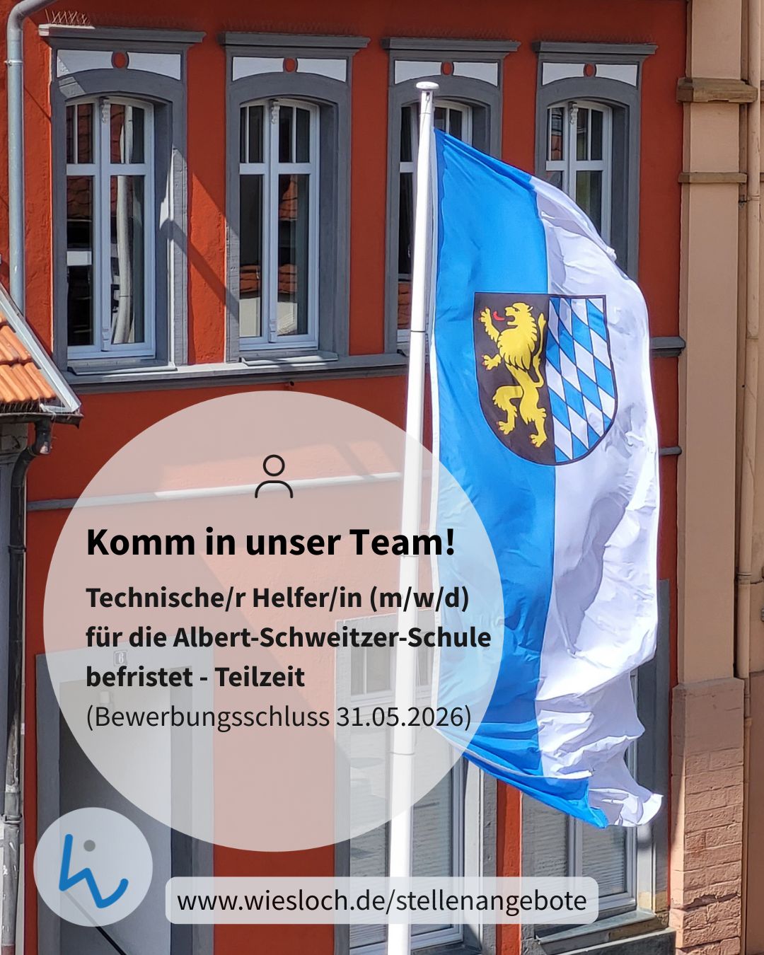 Dieser Alternativtext wurde KI-generiert: Ein Gebäude mit Fenstern und einem blau-weißen Banner. Das Banner enthält einen goldenen Löwen und Text, der auf eine Stellenausschreibung hinweist.