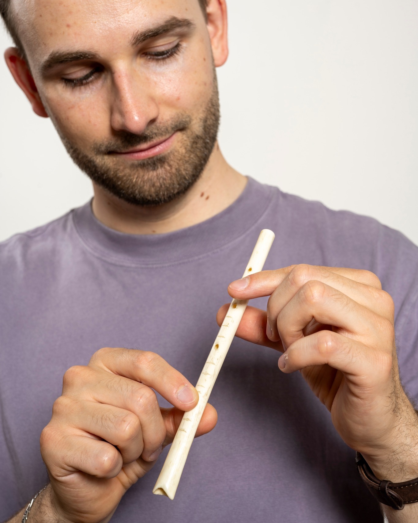 Dieser Alternativtext wurde KI-generiert: Eine Person hält ein weißes Blasinstrument in den Händen. Die Aufnahme ist farbig und zeigt einen Ausschnitt von oben.