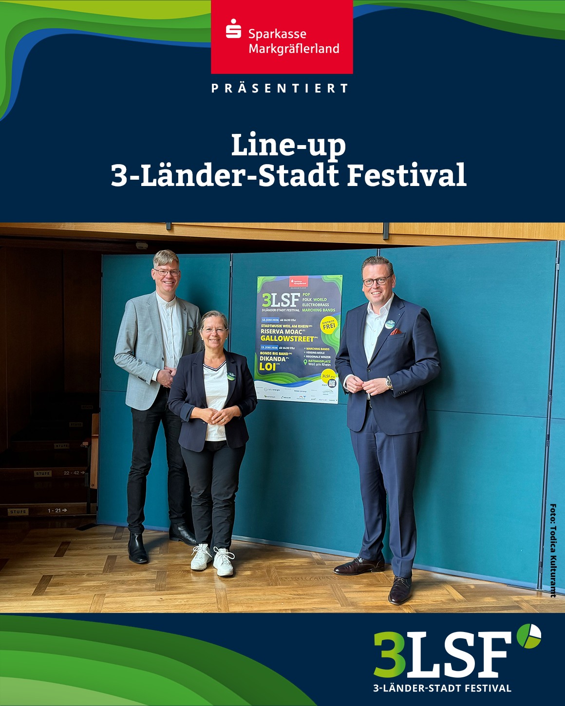 Dieser Alternativtext wurde KI-generiert: Ein farbiges Foto zeigt drei Personen vor einem Werbebanner. Das Banner bewirbt ein Festival und ist mit Logos versehen.