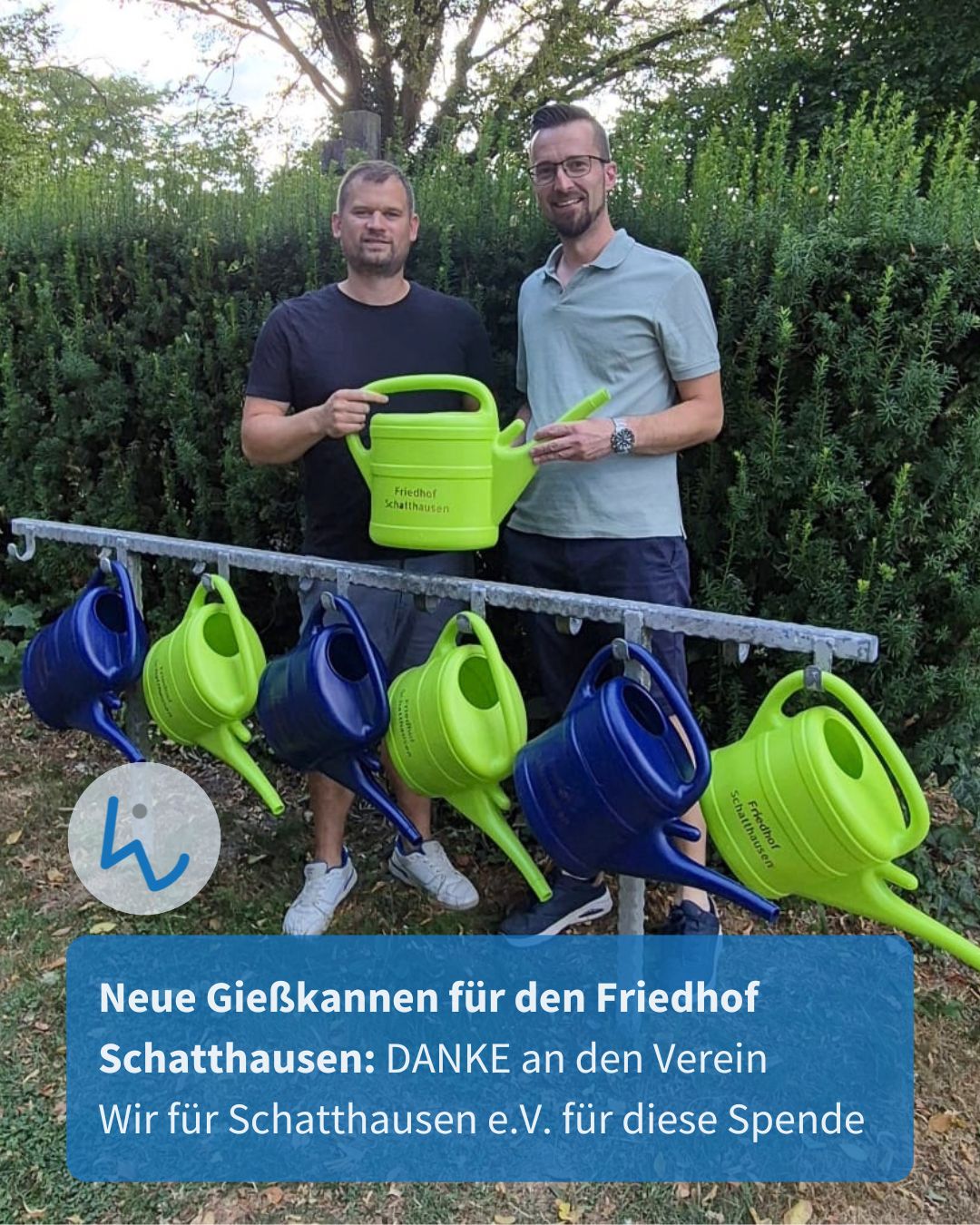 Zwei Personen stehen vor einer Hecke und halten eine grüne Gießkanne mit der Aufschrift „Friedhof Schatthausen“. Davor hängt ein Gestell mit weiteren blauen und grünen Gießkannen. Ein blauer Textbalken unten dankt dem Verein „Wir für Schatthausen e.V.“ für die Spende neuer Gießkannen. (KI-Alternativtext)