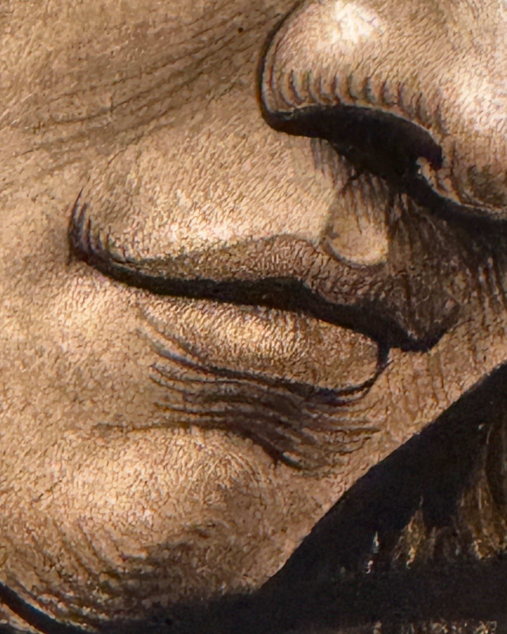Nahaufnahme eines geschlossenen Auges mit starkem, schwarzem Eyeliner. Dünne, federartige Linien sind unter dem Auge aufgetragen, während dicke Striche das Lid umrahmen. Die Hauttextur ist im warmen Licht detailliert erkennbar. (KI-Alternativtext)