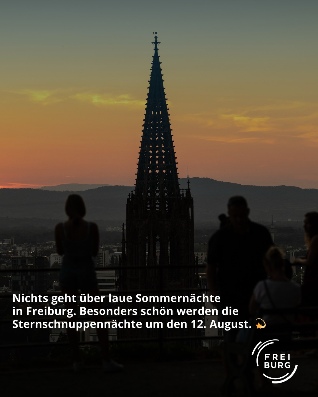 Dieser Alternativtext wurde KI-generiert: Schwarz-Weiß-Foto eines hohen Kirchturms vor einem Abendhimmel. Im Vordergrund sind die Silhouetten von Menschen zu sehen.