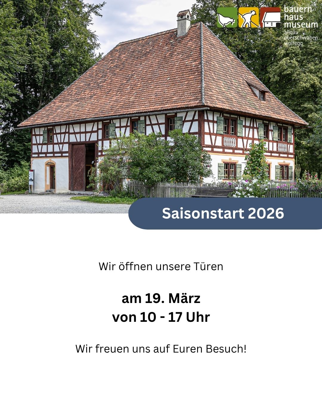 Dieser Alternativtext wurde KI-generiert: Ein traditionelles Fachwerkhaus mit einem roten Ziegeldach und grünen Fensterläden. Ein blaues Banner bewirbt eine saisonale Eröffnung im März.
