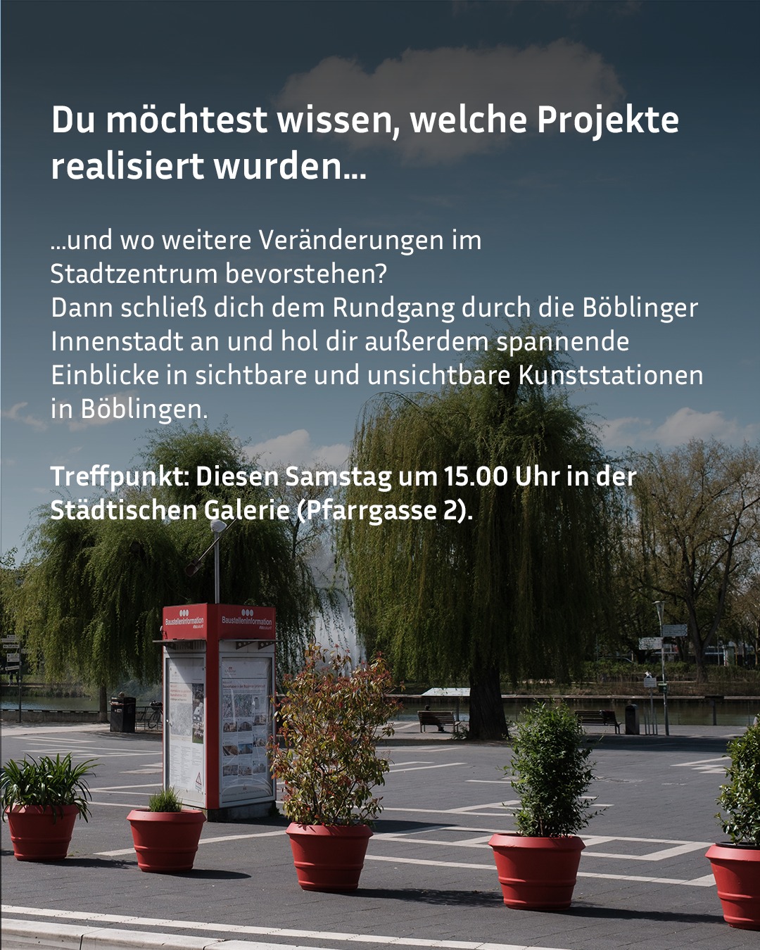 Dieser Alternativtext wurde KI-generiert: Ein Stadtplatz mit mehreren roten Pflanzkübeln und Informationstafeln im Vordergrund. Im Hintergrund sind Gebäude und Bäume zu sehen.