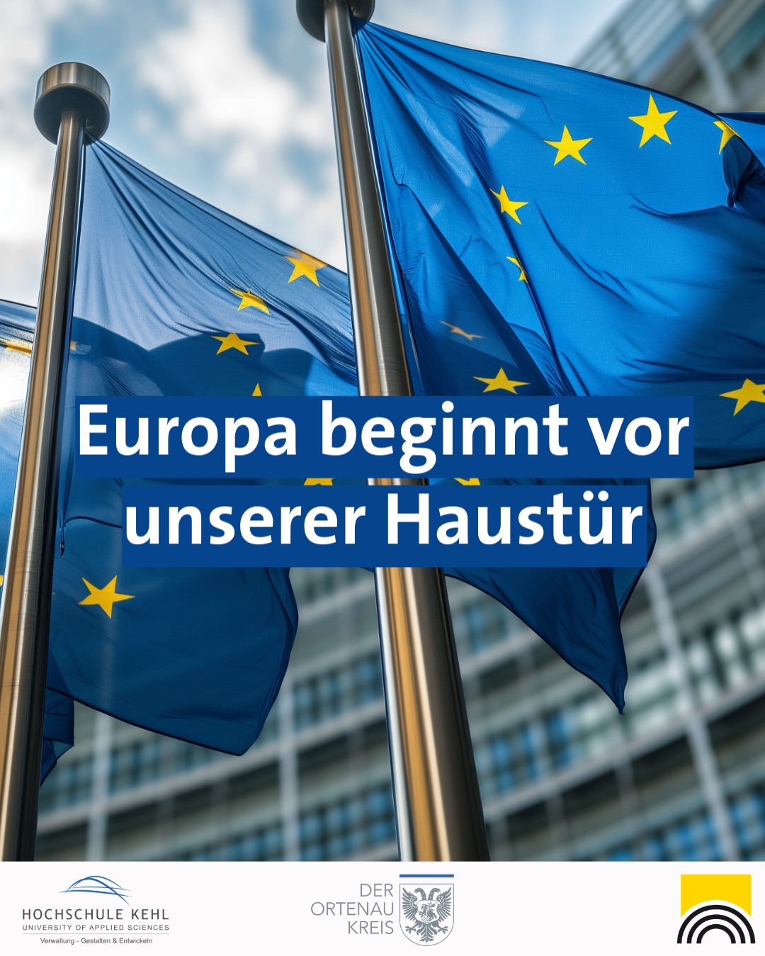 Dieser Alternativtext wurde KI-generiert: Eine blau-gelbe Flagge mit Sternen weht im Wind. Im Hintergrund ist ein Gebäude und Text auf dem Bild zu sehen.