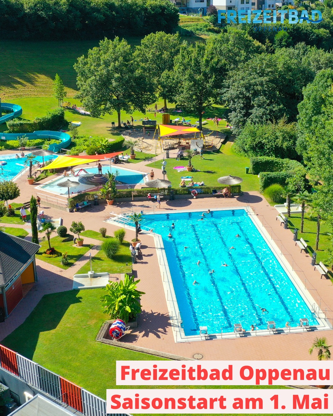 Dieser Alternativtext wurde KI-generiert: Ein weitläufiger Schwimmbadkomplex mit mehreren Pools und Liegewiesen ist von grünen Bäumen umgeben. Menschen verbringen Zeit beim Schwimmen und Sonnenbaden.