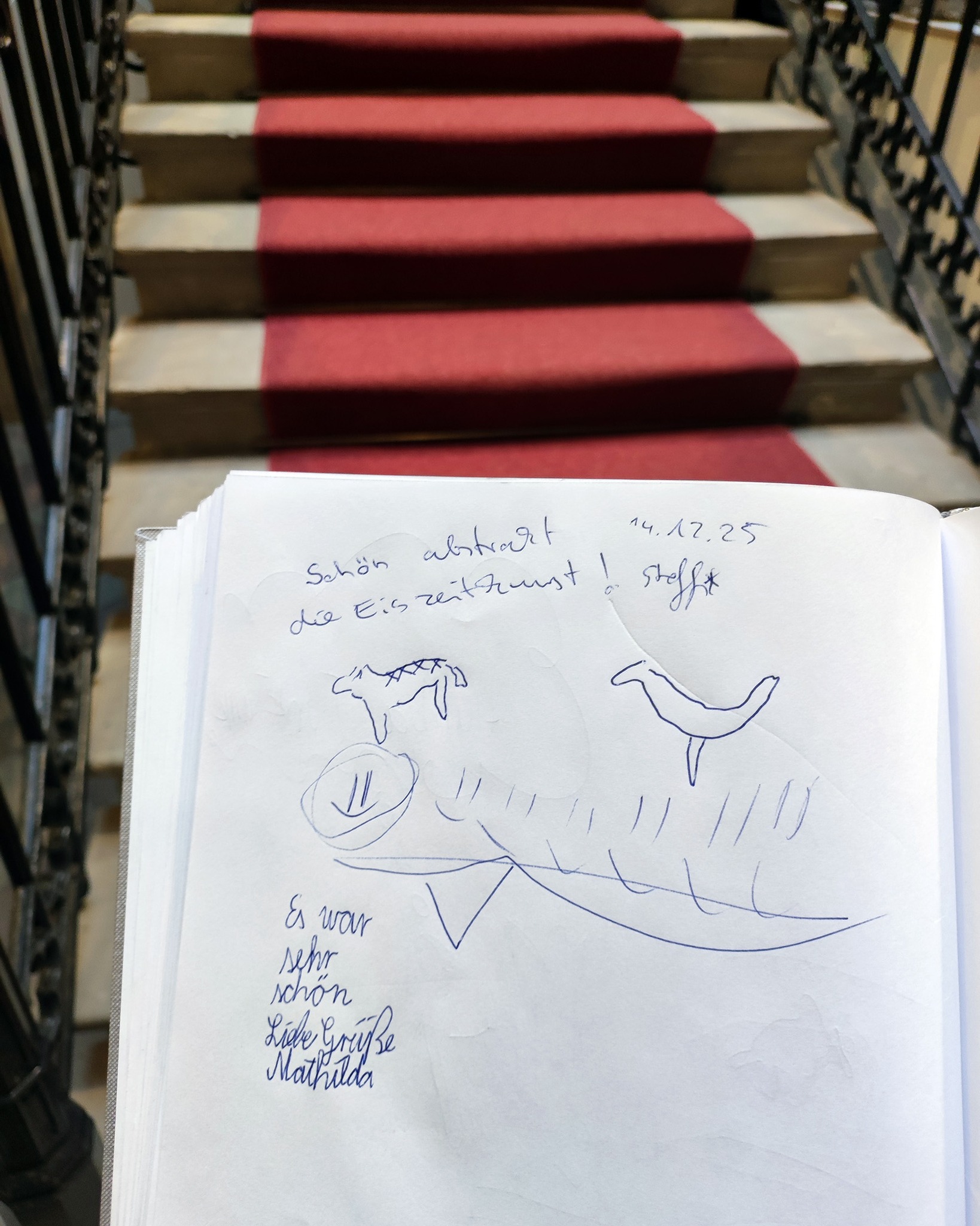 Dieser Alternativtext wurde KI-generiert: Ein offenes Skizzenbuch liegt auf einer Treppenstufe mit rotem Teppich. Das Skizzenbuch zeigt eine handgezeichnete Skizze und handschriftliche Notizen.