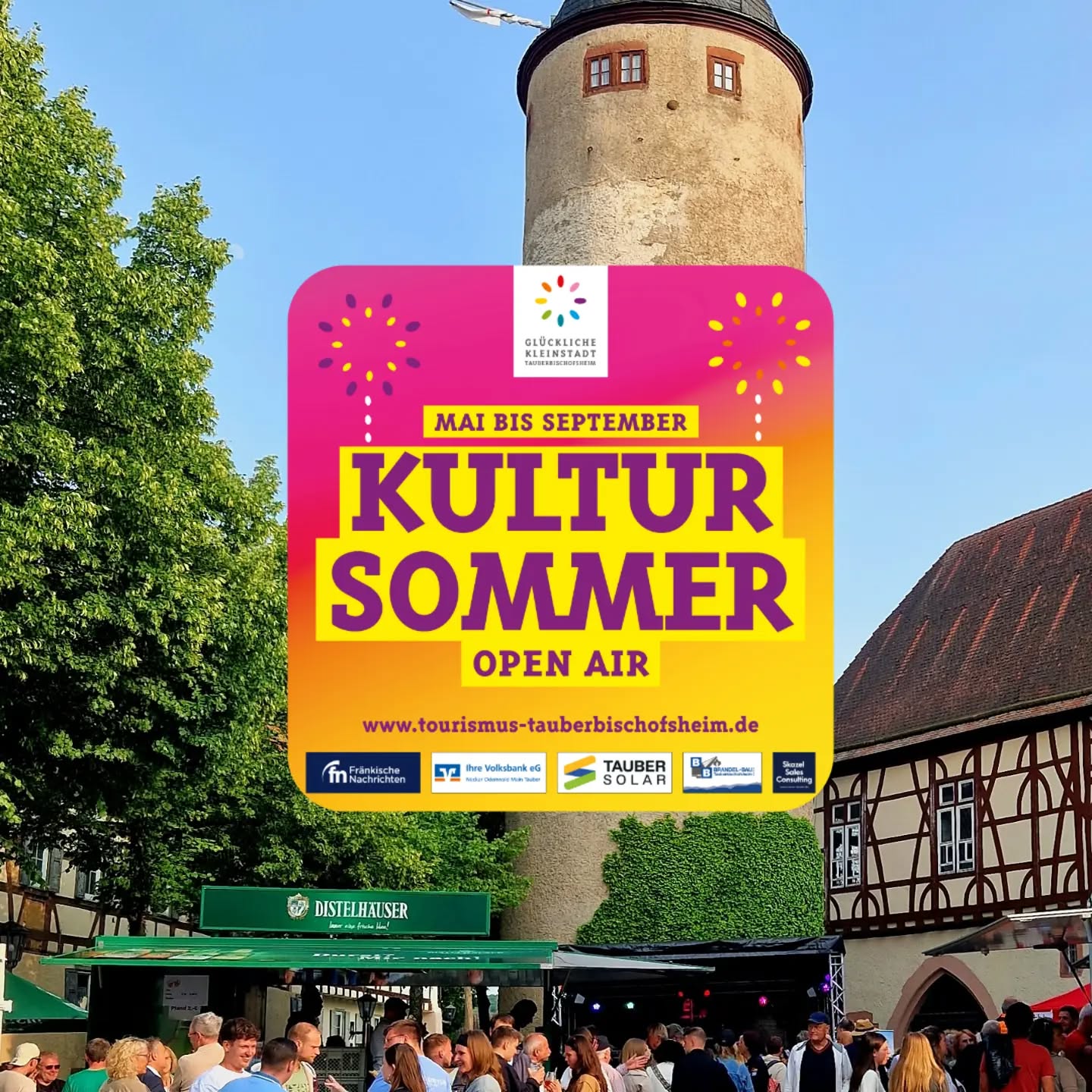 Ein farbenfrohes Plakat mit der Aufschrift „Kultur Sommer Open Air“ und dem Zeitraum „Mai bis September“ überlagert eine Platzszene. Im Hintergrund erheben sich ein steinerner Turm und ein Fachwerkhaus, während im Vordergrund eine Menschenmenge vor einer Bühne steht. Am unteren Rand des Plakats sind Sponsorenlogos und die Webadresse www.tourismus-tauberbischofsheim.de abgebildet. (KI-Alternativtext)