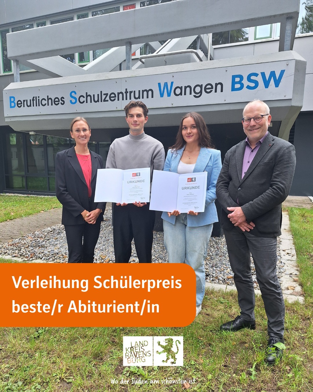 Dieser Alternativtext wurde KI-generiert: Eine Gruppe von vier Personen steht vor einem Gebäude mit einem Banner. Sie halten Urkunden in den Händen und lächeln in die Kamera.