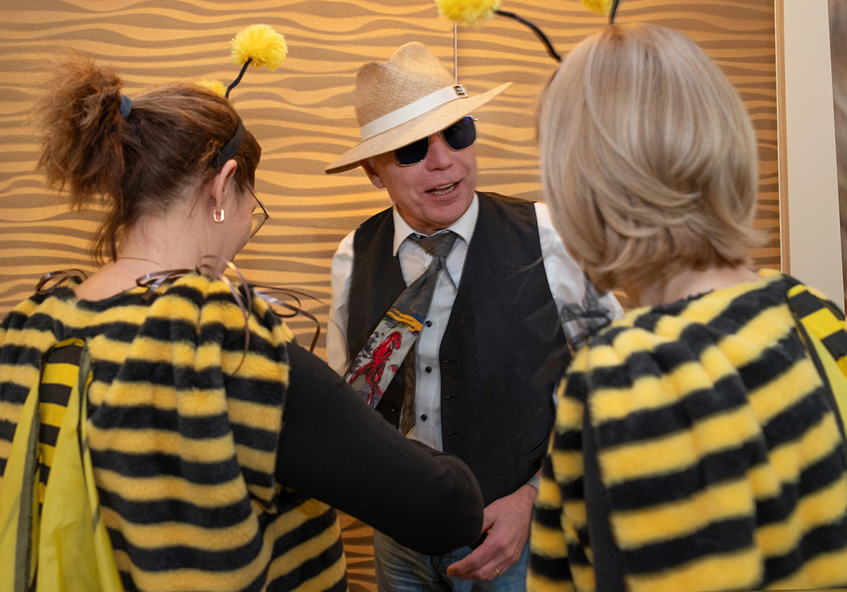 Dieser Alternativtext wurde KI-generiert: Mehrere Personen in Kostümen stehen zusammen in einem Raum. Einige der Kostüme scheinen Bienen oder Imker darzustellen.