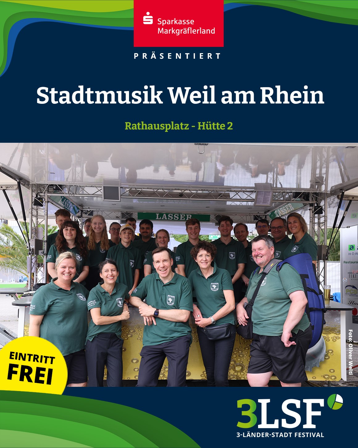 Dieser Alternativtext wurde KI-generiert: Ein farbiges Bild zeigt eine Gruppe von Menschen vor einem Stand mit Beschriftungen und Logos. Im Hintergrund ist eine belebte Szene mit einem Gebäude und Bäumen zu erkennen.