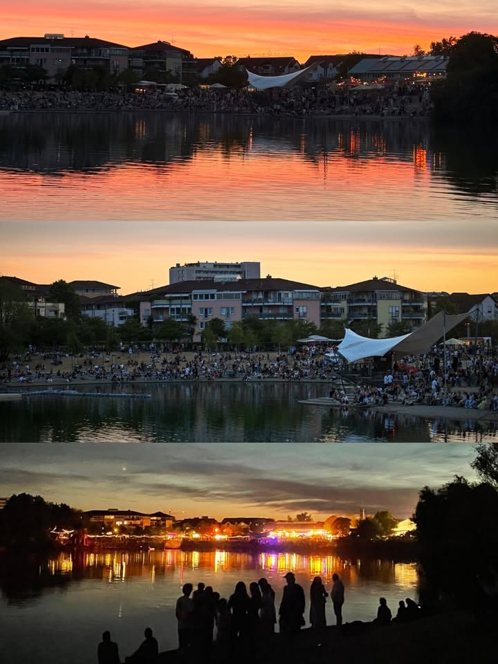 Drei aufeinanderfolgende Aufnahmen zeigen den Übergang von Sonnenuntergang zur Nacht an einem belebten Seeufer. Die oberen Bilder präsentieren den orangefarbenen Himmel und dessen Spiegelung im Wasser vor einer Kulisse aus Wohngebäuden und einer großen Menschenmenge. Das unterste Bild zeigt die Szene bei Dunkelheit mit bunten Lichtreflexionen auf dem Wasser und Silhouetten von Personen im Vordergrund. (KI-Alternativtext)