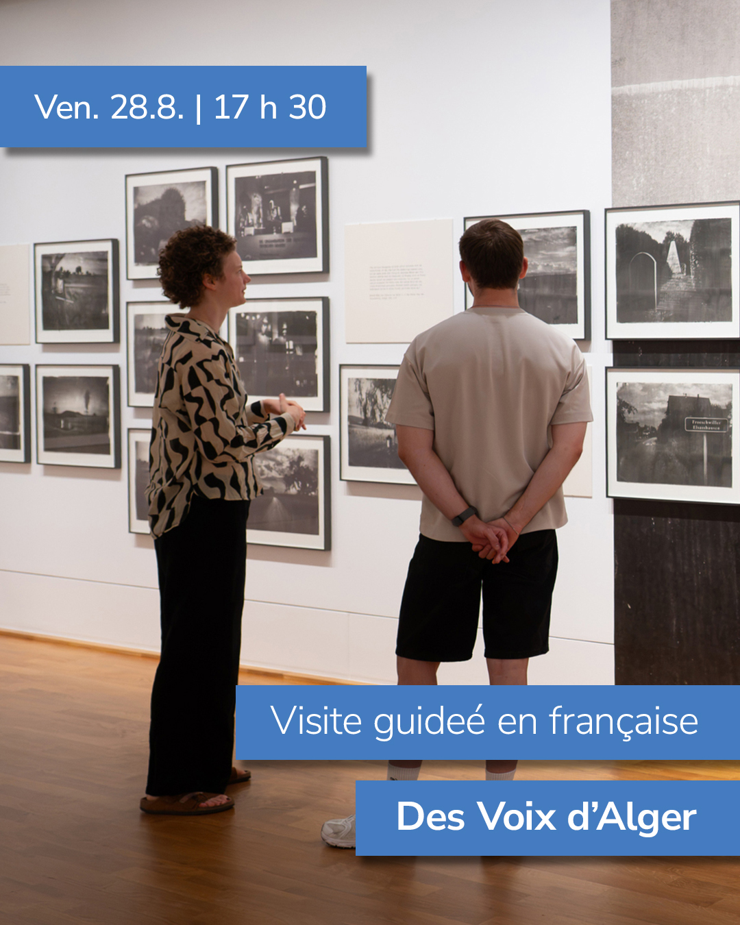 Zwei Personen stehen in einer Galerie und betrachten gerahmte Schwarz-Weiß-Fotografien an einer weißen Wand. Ein blauer Balken oben links enthält den Text „Ven. 28.8. | 17 h 30“. Unten rechts stehen in blauen Balken die Texte „Visite guidée en française“ und „Des Voix d'Alger“. (KI-Alternativtext)