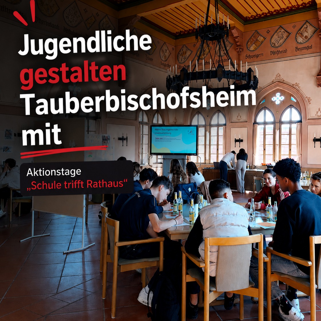 Jugendliche gestalten im Tauberbischofsheim mit Aktionstagen „Schule trifft Rathaus“. Sie sitzen an Tischen in einem großen Saal mit Wappen an den Wänden und arbeiten vor einem Bildschirm. (KI-Alternativtext)