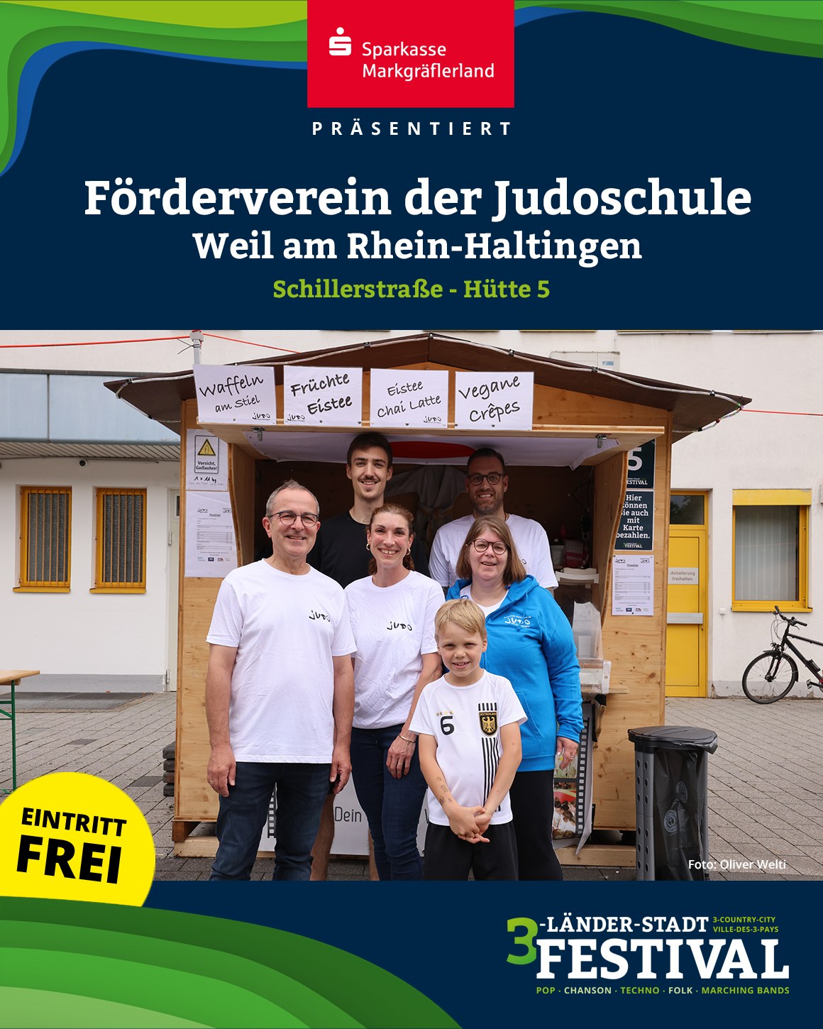 Eine Gruppe von Personen steht vor einem Stand mit Speiseangeboten. Im Hintergrund ist ein Fahrrad zu sehen.