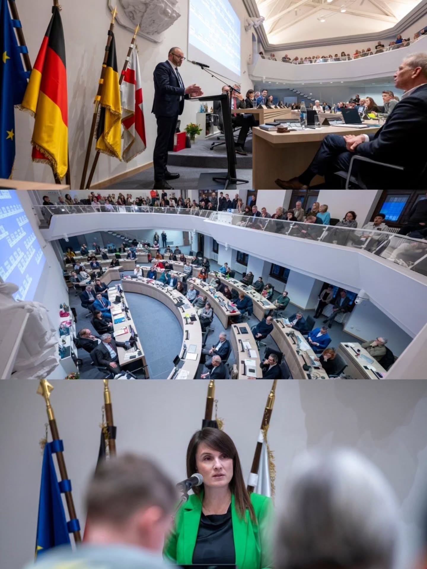 Dieser Alternativtext wurde KI-generiert: Ein Innenraum mit einer Zuschauertribüne und Menschen, die an Tischen sitzen. Eine Person steht auf einer Erhöhung und spricht, während eine andere Person im Vordergrund zu Wort ist.