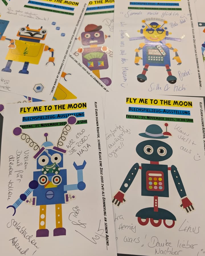 Dieser Alternativtext wurde KI-generiert: Farbige Illustrationen von Robotern und dem Mond auf einem Plakat. Es enthält handschriftliche Texte und Informationen zu einer Ausstellung.