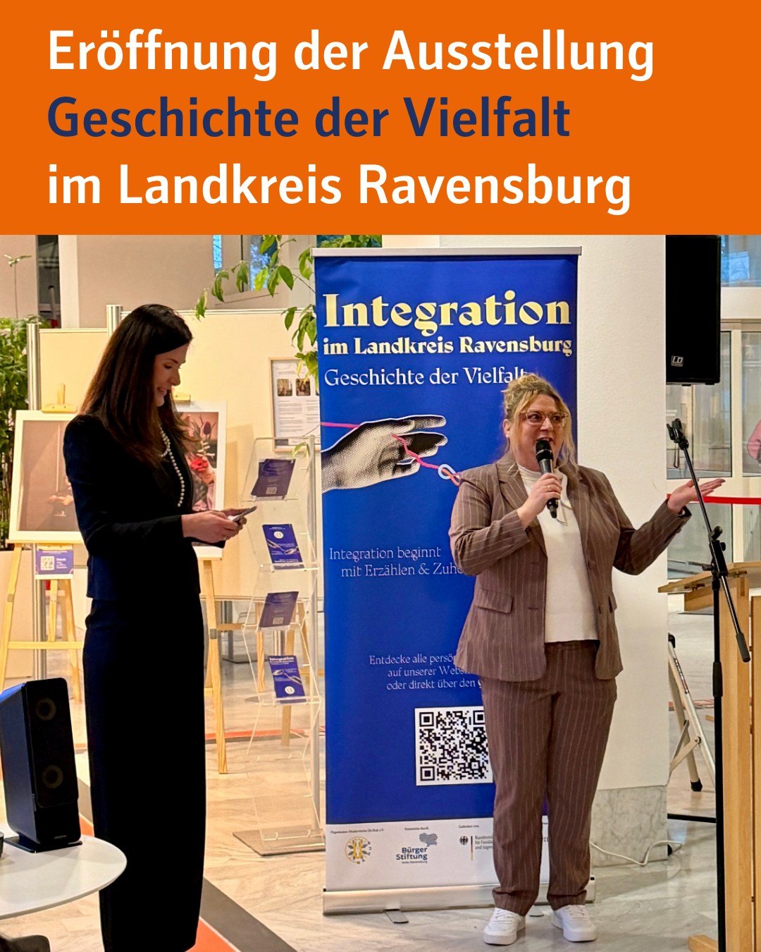 Bildtext: Eröffnung der Ausstellung "Geschichten der Vielfalt" im Landkreis Ravensburg. Zu sehen ist unsere Dezernentin Tina Schädler, sowie eine Person des Vereins UAHUB bei der Eröffnung der Ausstellung.