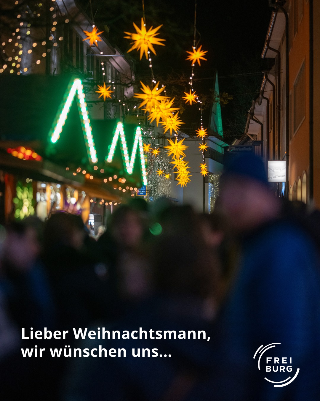 Dieser Alternativtext wurde KI-generiert: Ein beleuchtetes Stadtbild mit vielen Lichtern und einer grünen Botschaft. Im Vordergrund befindet sich ein Schriftzug und ein Logo.