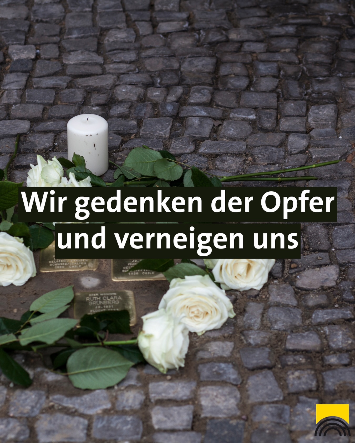 Dieser Alternativtext wurde KI-generiert: Ein Schwarz-Weiß-Foto zeigt eine Gedenkstätte mit Blumen, Kerzen und einem Gedenkschild auf einem gepflasterten Platz. Der Text auf dem Bild lautet: "Wir gedenken der Opfer und verneigen uns."