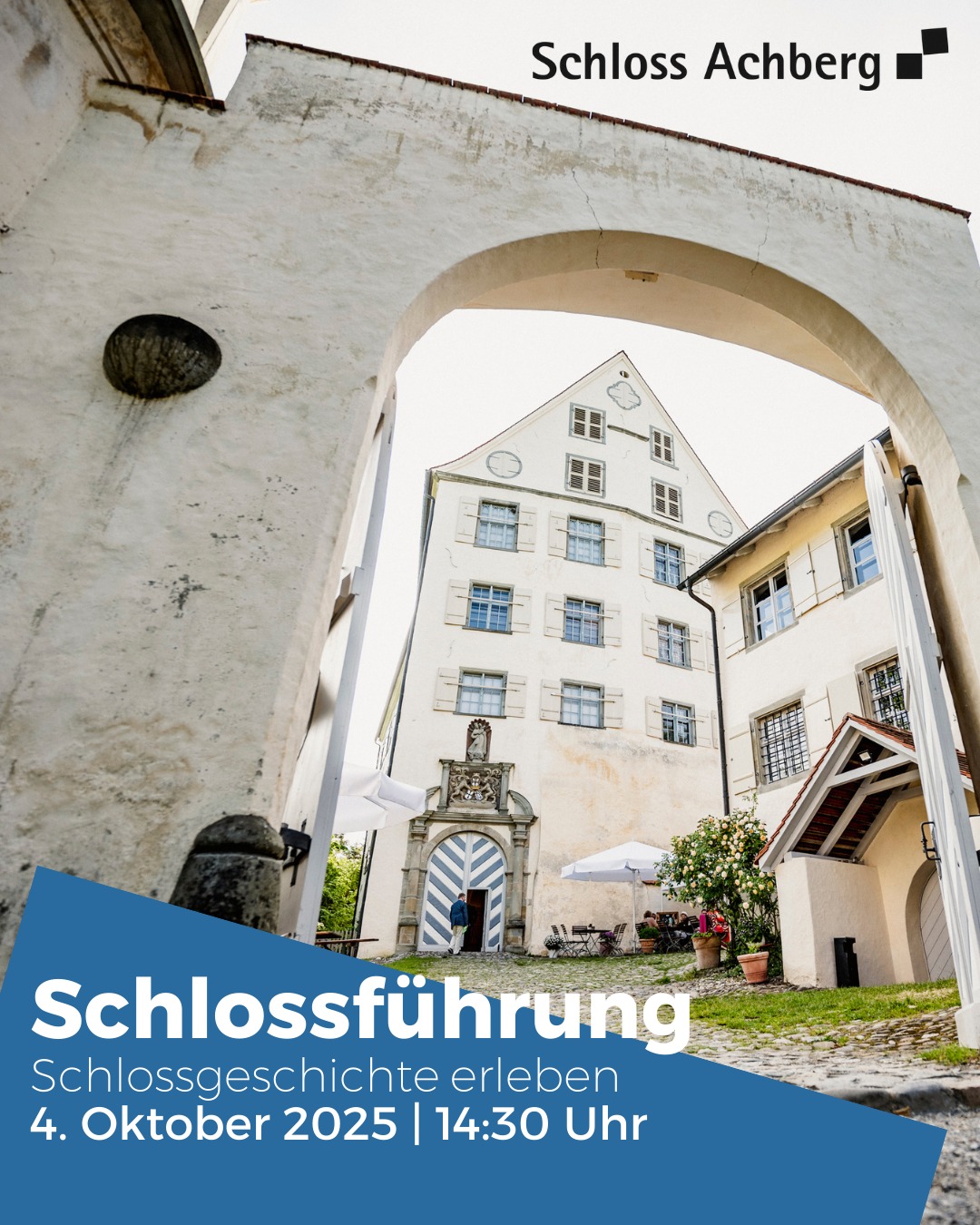 Dieser Alternativtext wurde KI-generiert: Ein Gebäude ist durch einen Bogen zu sehen. Im Vordergrund befindet sich ein Werbebanner mit Informationen zu einer Schlossführung.