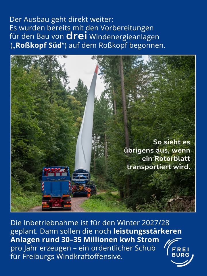 Dieser Alternativtext wurde KI-generiert: Ein Windkraftanlagenrotorblatt wird auf einem Transportfahrzeug auf einer befestigten Straße transportiert. Im Hintergrund ist eine weitere Windkraftanlage und eine Landschaft zu sehen.
