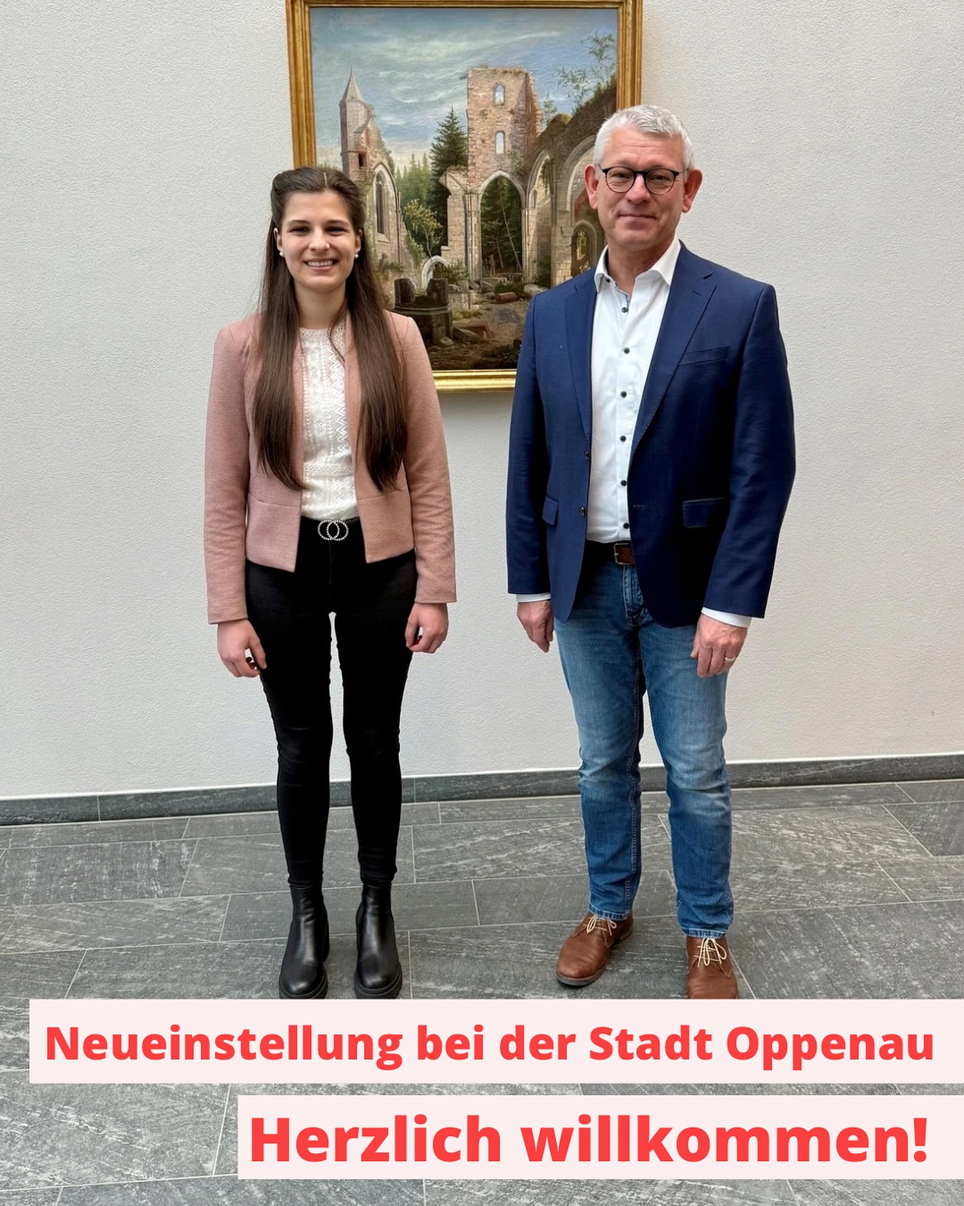 Bild zeigt zwei Personen in formeller Kleidung vor einem Gemälde. Herzlich Willkommen im neuen Team!