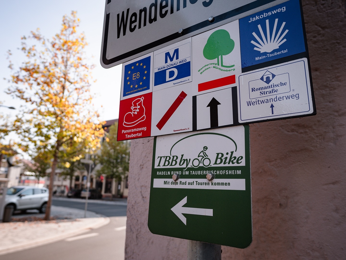 Wegweiser mit verschiedenen Wander- und Radwegen. Die Schilder zeigen verschiedene Symbole und Richtungen.