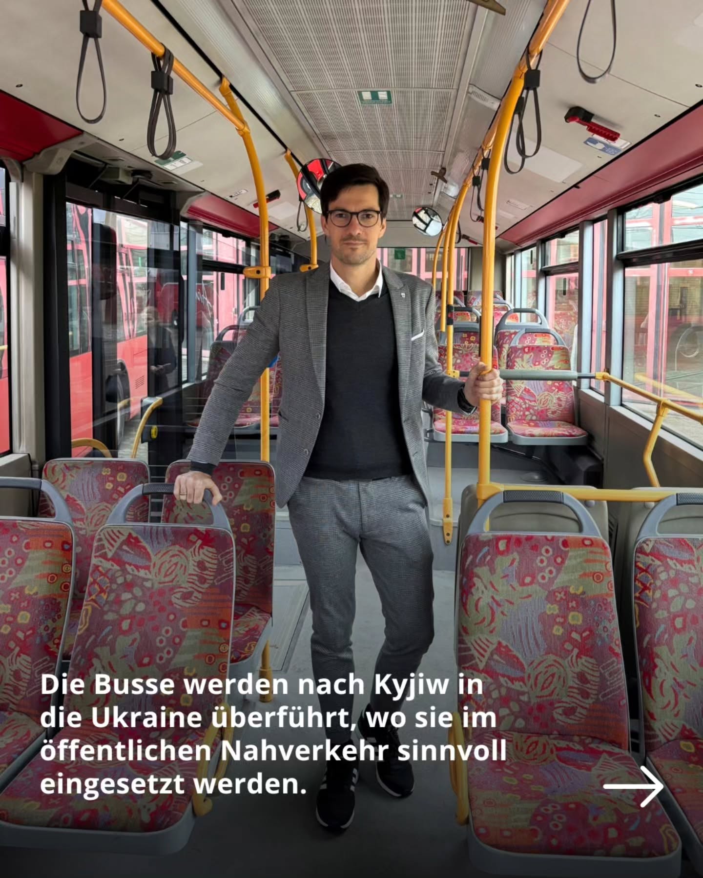Dieser Alternativtext wurde KI-generiert: Eine Person steht in einem Bus, der mit farbigen Mustern verziert ist. Im Hintergrund sind Reihen von Sitzen und Fenster zu sehen.