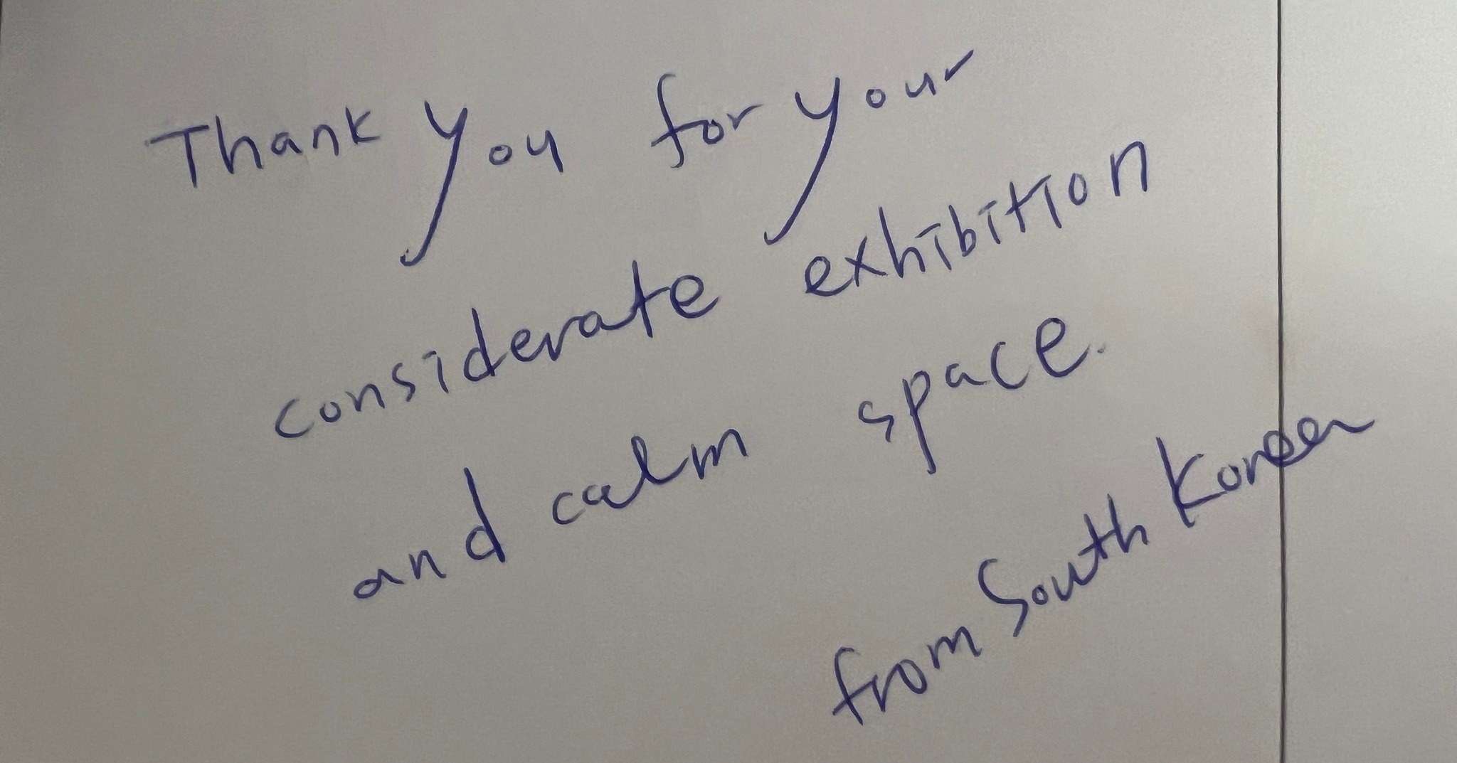 Dieser Alternativtext wurde KI-generiert: Schwarz-Weiß-Foto einer handgeschriebenen Notiz. Auf der Notiz steht ein Dankeschön für die Ausstellung und einen ruhigen Ausstellungsraum, unterzeichnet mit 'from South Korea'.