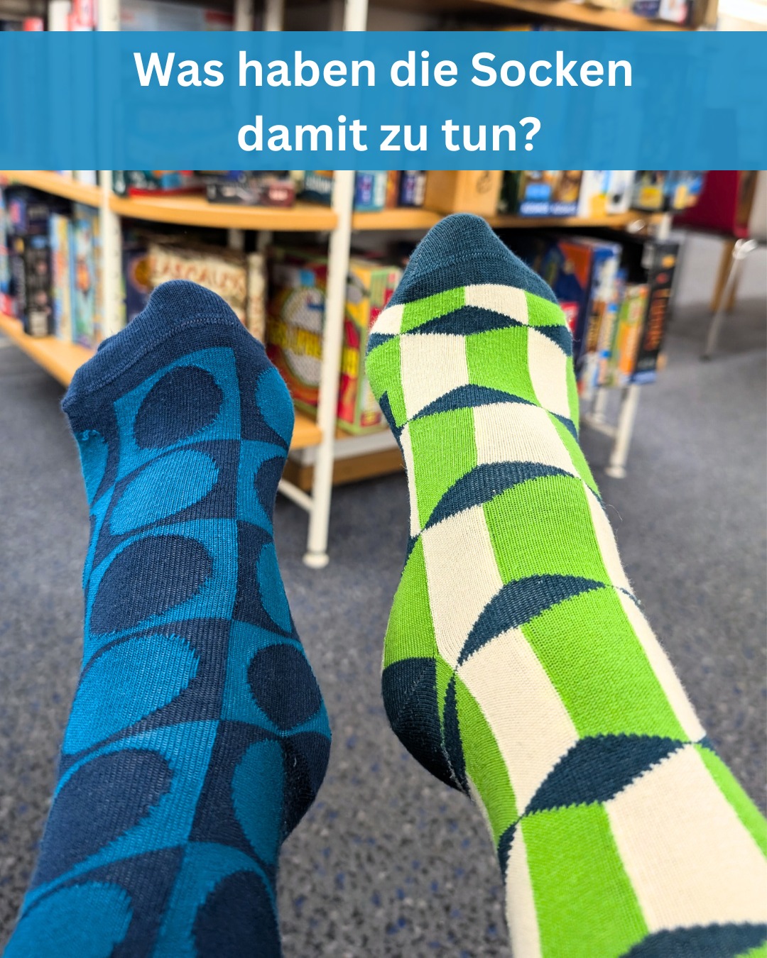 Zwei Socken mit geometrischen Mustern sind auf dem Boden vor einem Bücherregal zu sehen. Die Frage lautet: Was haben die Socken damit zu tun?