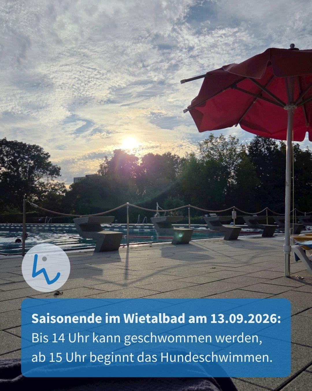 Freibad bei Sonnenuntergang mit rotem Sonnenschirm und Bänken im Vordergrund. Im Pool schwimmt eine Person. Ein blauer Textkasten unten informiert: Saisonende im Wietalbad am 13.09.2026: Bis 14 Uhr kann geschwommen werden, ab 15 Uhr beginnt das Hundeschwimmen. (KI-Alternativtext)