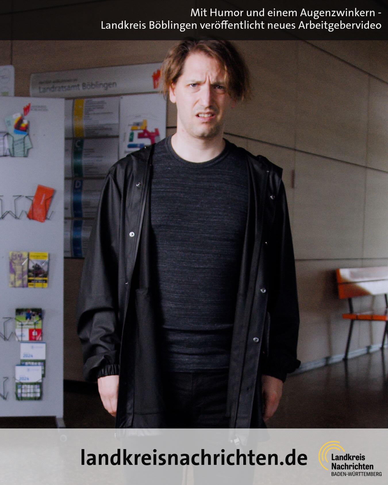 Person mit verwirrtem Gesichtsausdruck in dunkler Jacke vor einer Informationswand mit Schild „Landratsamt Böblingen“. Oben Text: „Mit Humor und einem Augenzwinkern – Landkreis Böblingen veröffentlicht neues Arbeitgebergvideo“. Unten Logo und „landkreisnachrichten.de“. (KI-Alternativtext)