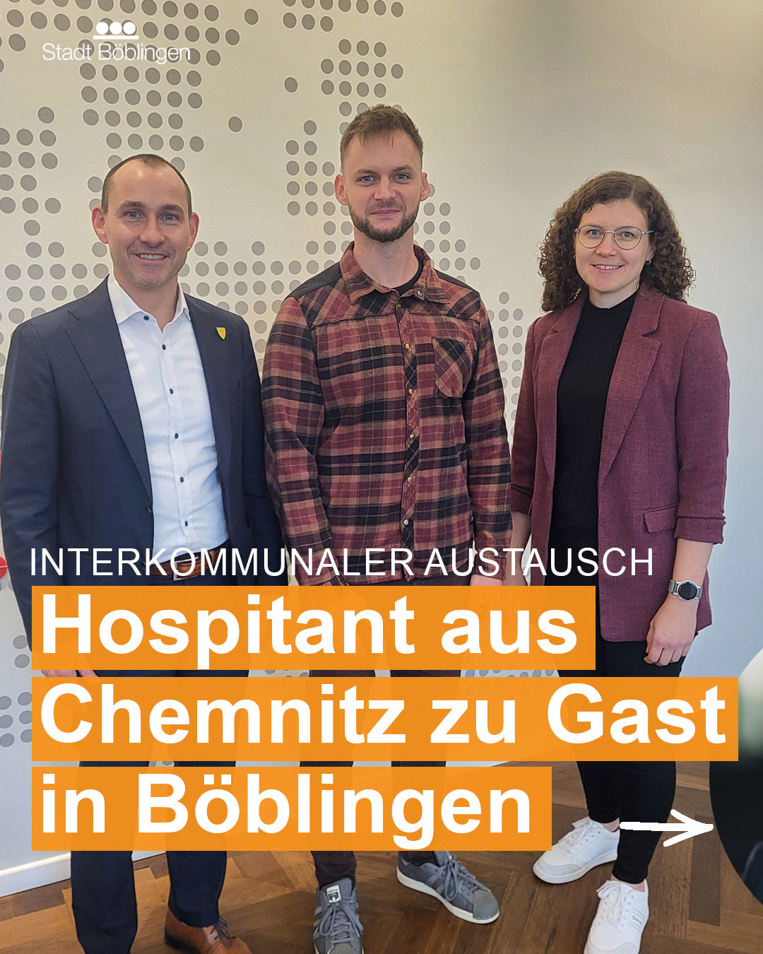 Dieser Alternativtext wurde KI-generiert: Ein farbiges Bild zeigt mehrere Personen, die nebeneinander posieren. Im Hintergrund befindet sich eine Wand mit einem Punktmuster und ein Werbebanner mit Text.