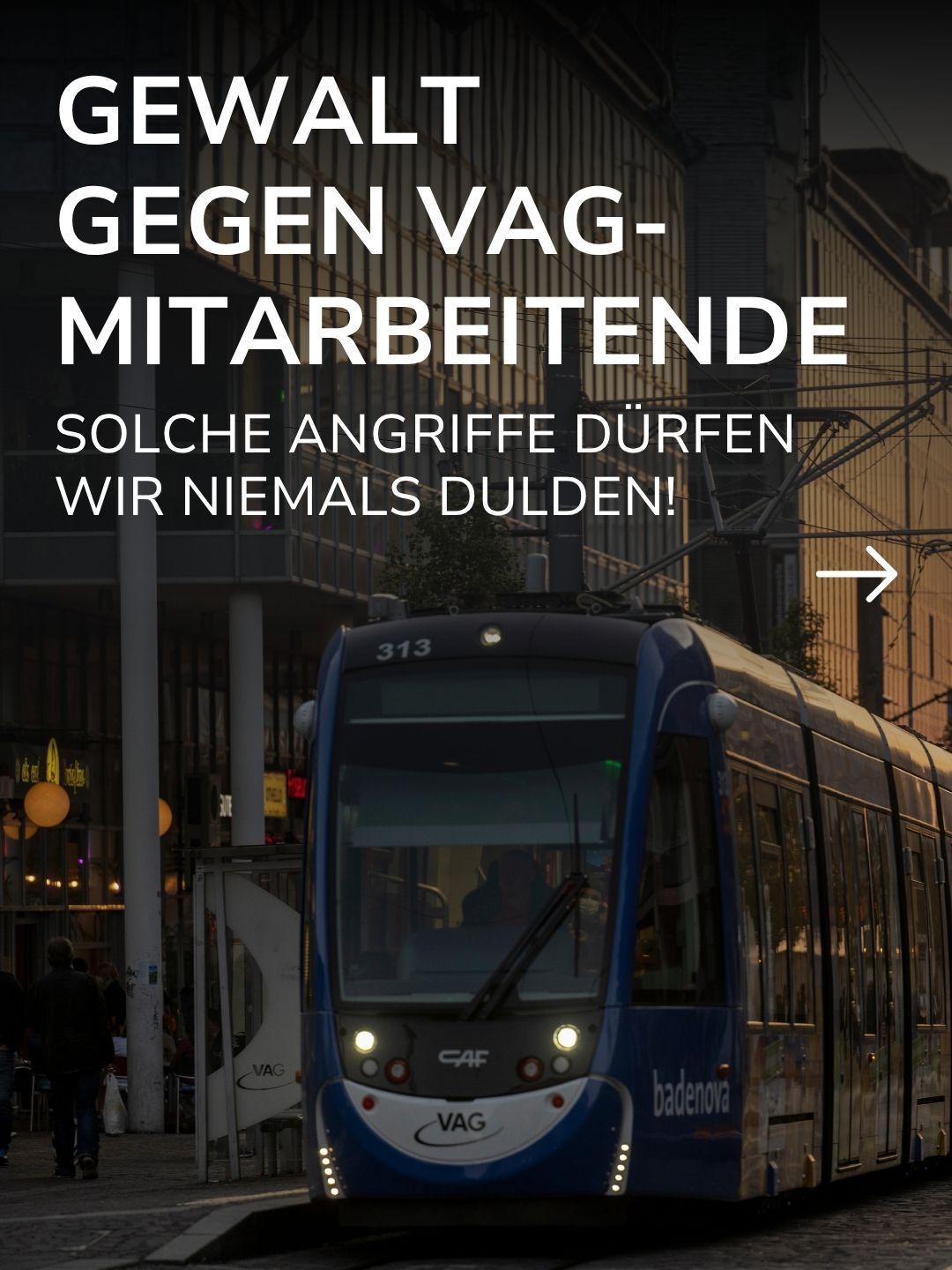 Große weiße Schrift überlagert ein Bild einer blauen Straßenbahn der VAG: GEWALT GEGEN VAG-MITARBEITENDE SOLCHE ANGRIFFE DÜRFEN WIR NIEMALS DULDEN! Ein weißer Pfeil zeigt nach rechts, während im Hintergrund Personen auf dem Gehweg zu sehen sind. (KI-Alternativtext)