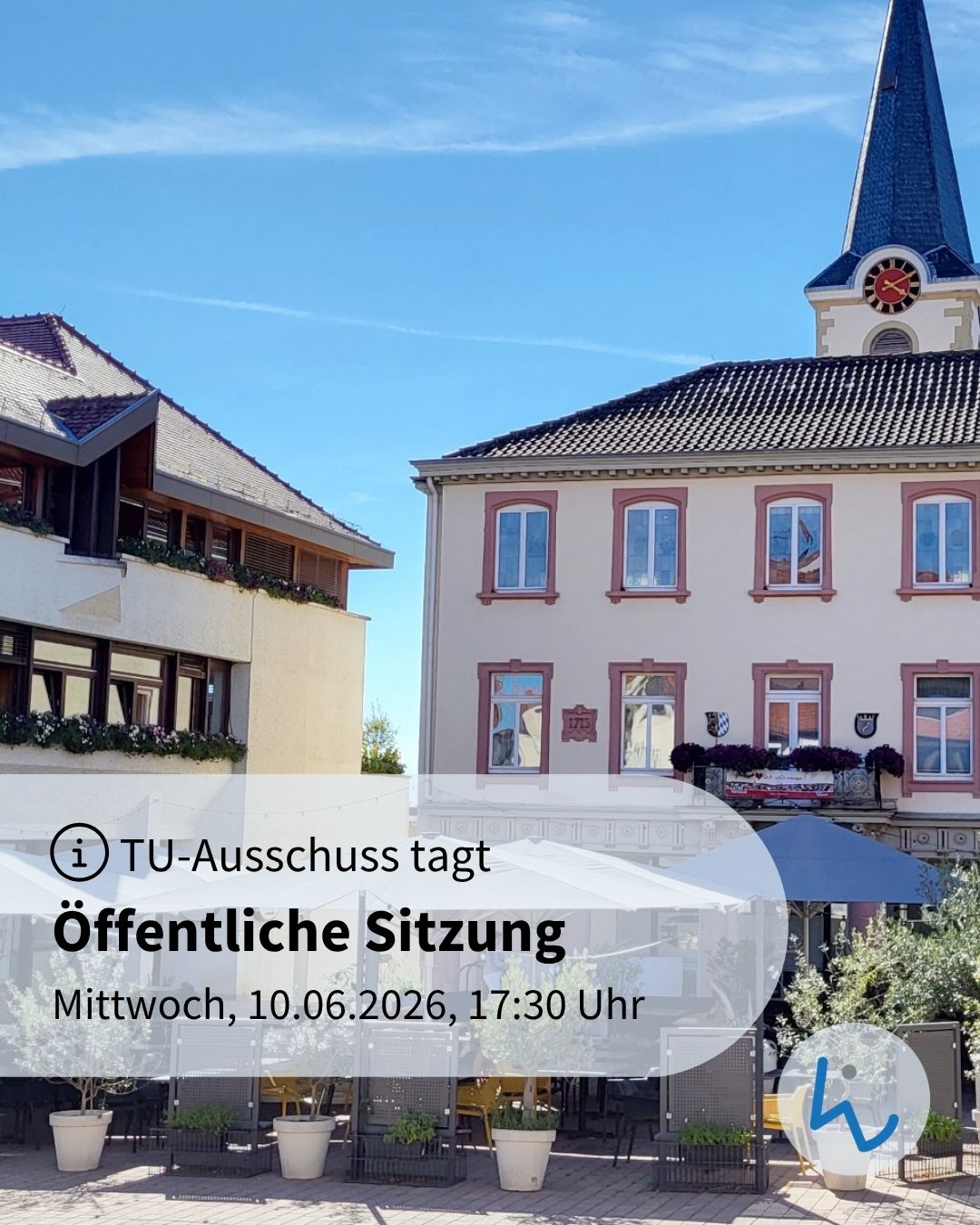 TU-Ausschuss tagt öffentlich am Mittwoch, 10.06.2026, 17:30 Uhr. Im Hintergrund ein Gebäude mit Turm und Uhr, davor ein Platz mit Tischen, Stühlen und Sonnenschirmen unter blauem Himmel. (KI-Alternativtext)