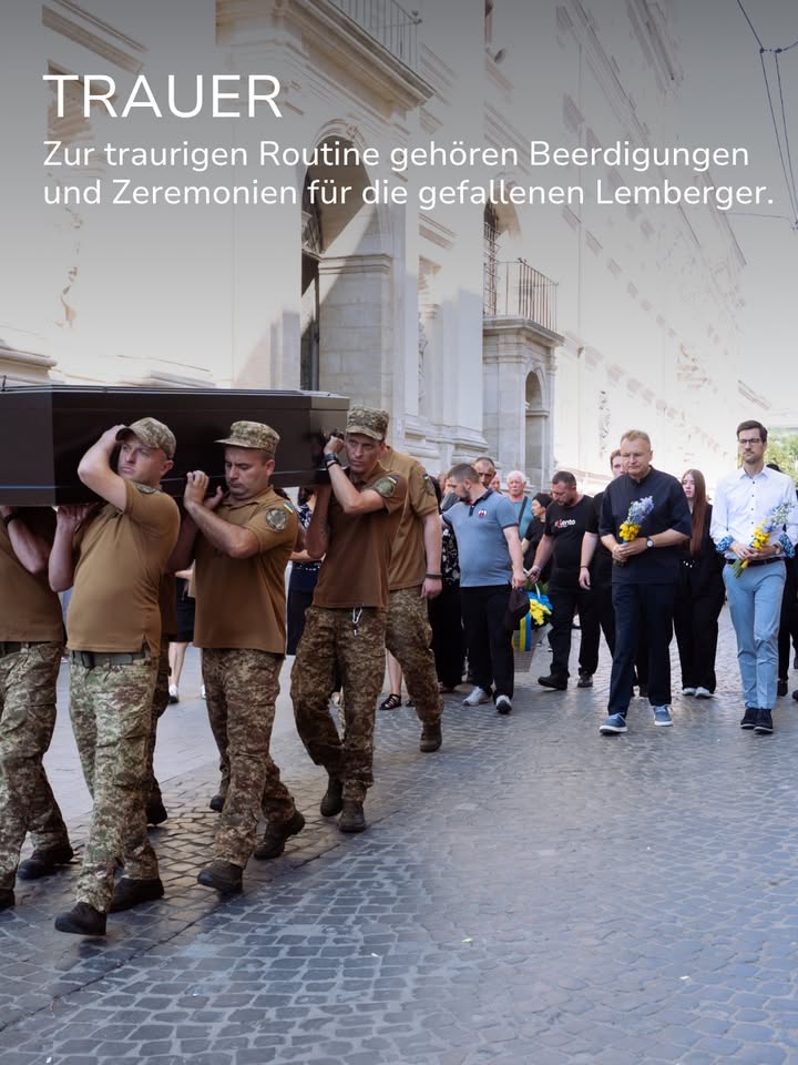 Personen in Uniform tragen einen schwarzen Sarg auf den Schultern, gefolgt von einer Gruppe, die teilweise Blumen hält. Oben steht der Text „TRAUER“ sowie „Zur traurigen Routine gehören Beerdigungen und Zeremonien für die gefallenen Lemberger.“ (KI-Alternativtext)
