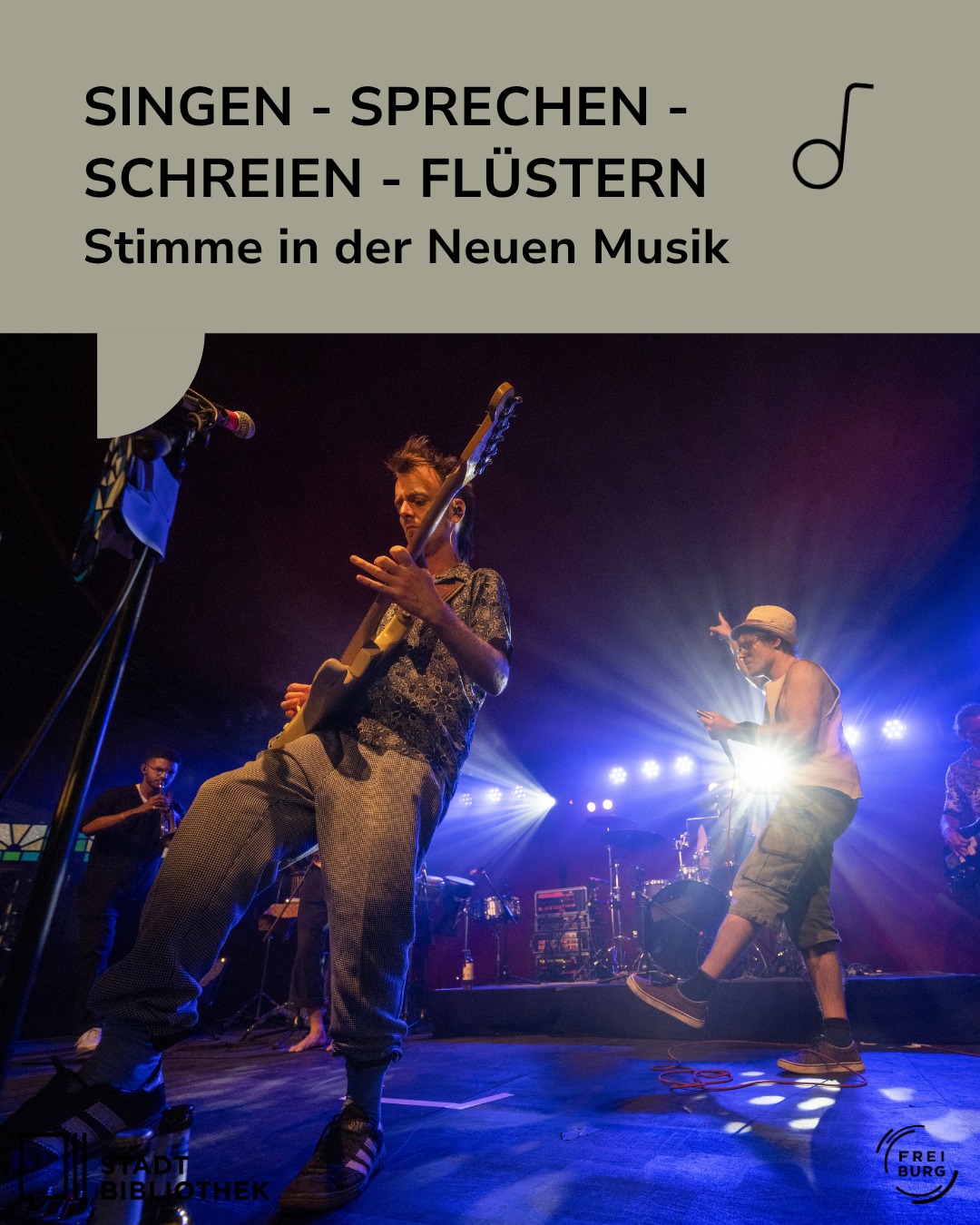 Dieser Alternativtext wurde KI-generiert: Schwarz-Weiß-Foto einer Bühnenperformance. Mehrere Personen mit Instrumenten stehen vor Scheinwerfern und spielen in einem Raum mit Zuschauern.