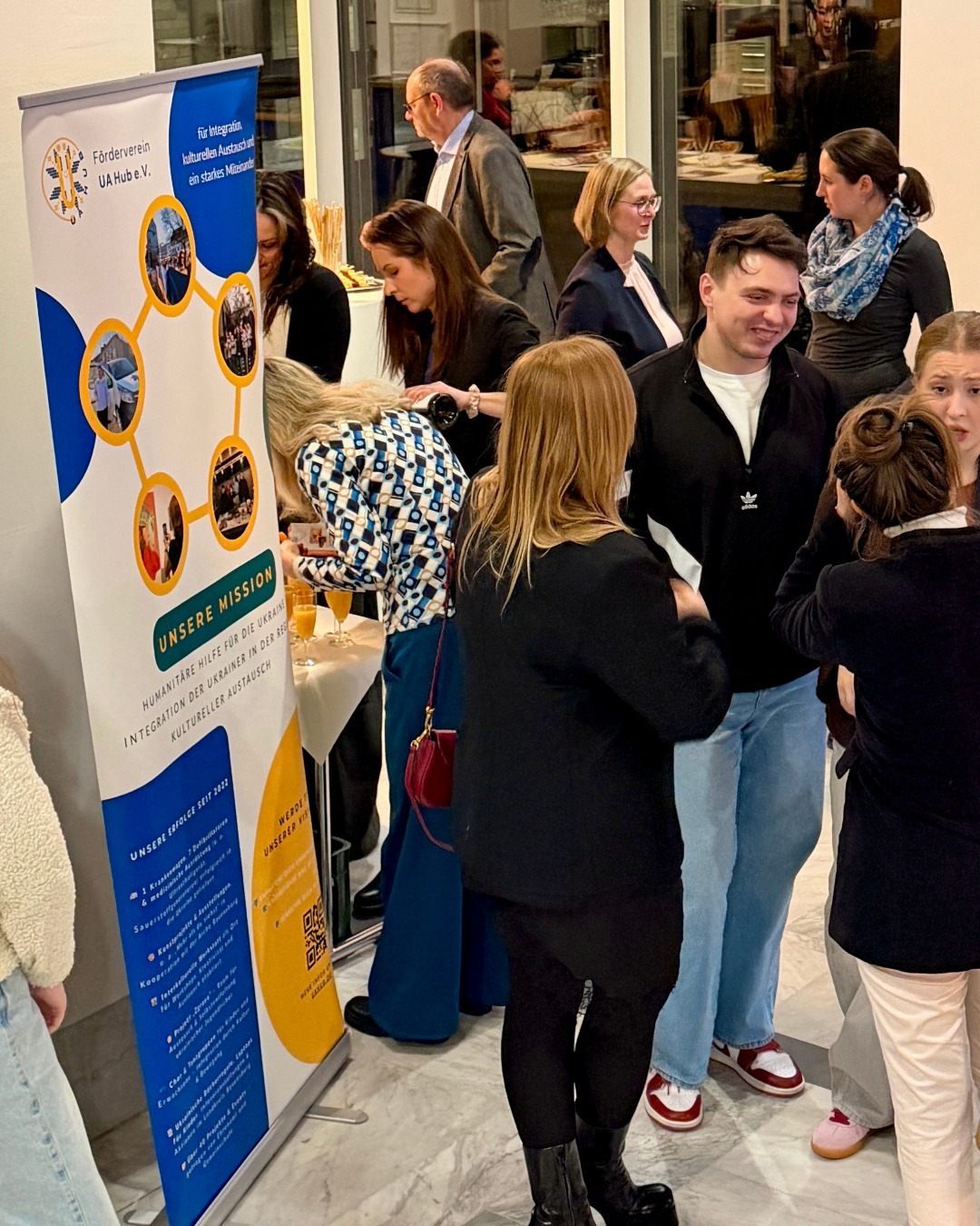 Personen schauen sich die Ausstellung an und sprechen mit den Verantwortlichen.