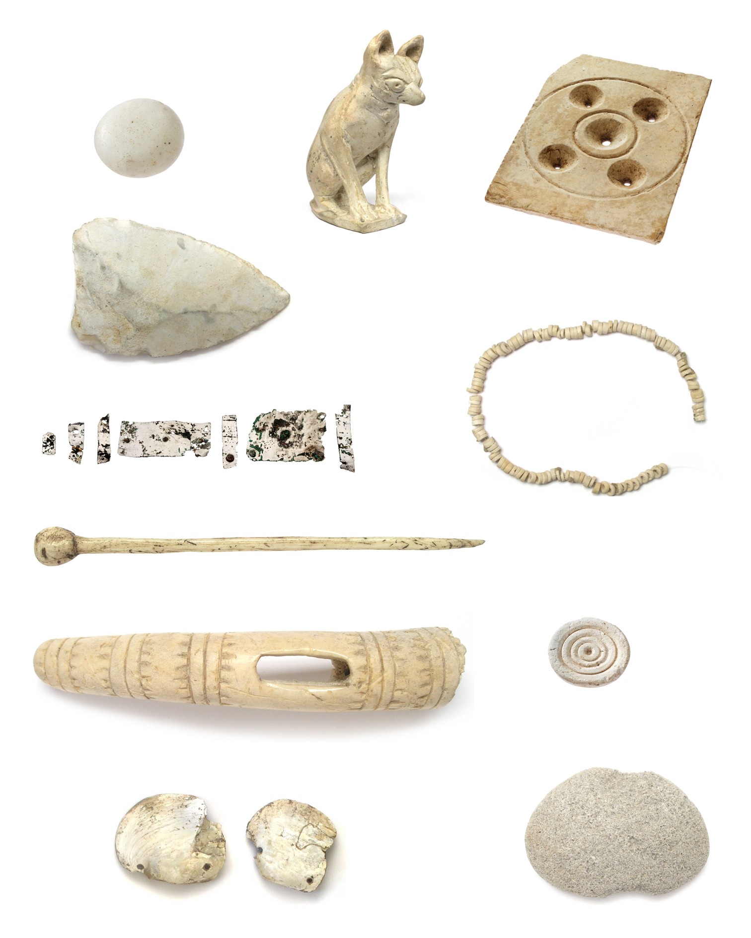 Verschiedene archäologische Funde auf weißem Hintergrund, darunter eine sitzende Tierfigur, ein quadratisches Spielbrett mit kreisförmigen Löchern, eine Kette aus kleinen Perlen, ein langer Knochenstift, ein graviertes Knochenstück mit Öffnung, Muschelfragmente, ein spiralförmiges Medaillon, Fragmente eines Streifens und mehrere Steine. (KI-Alternativtext)