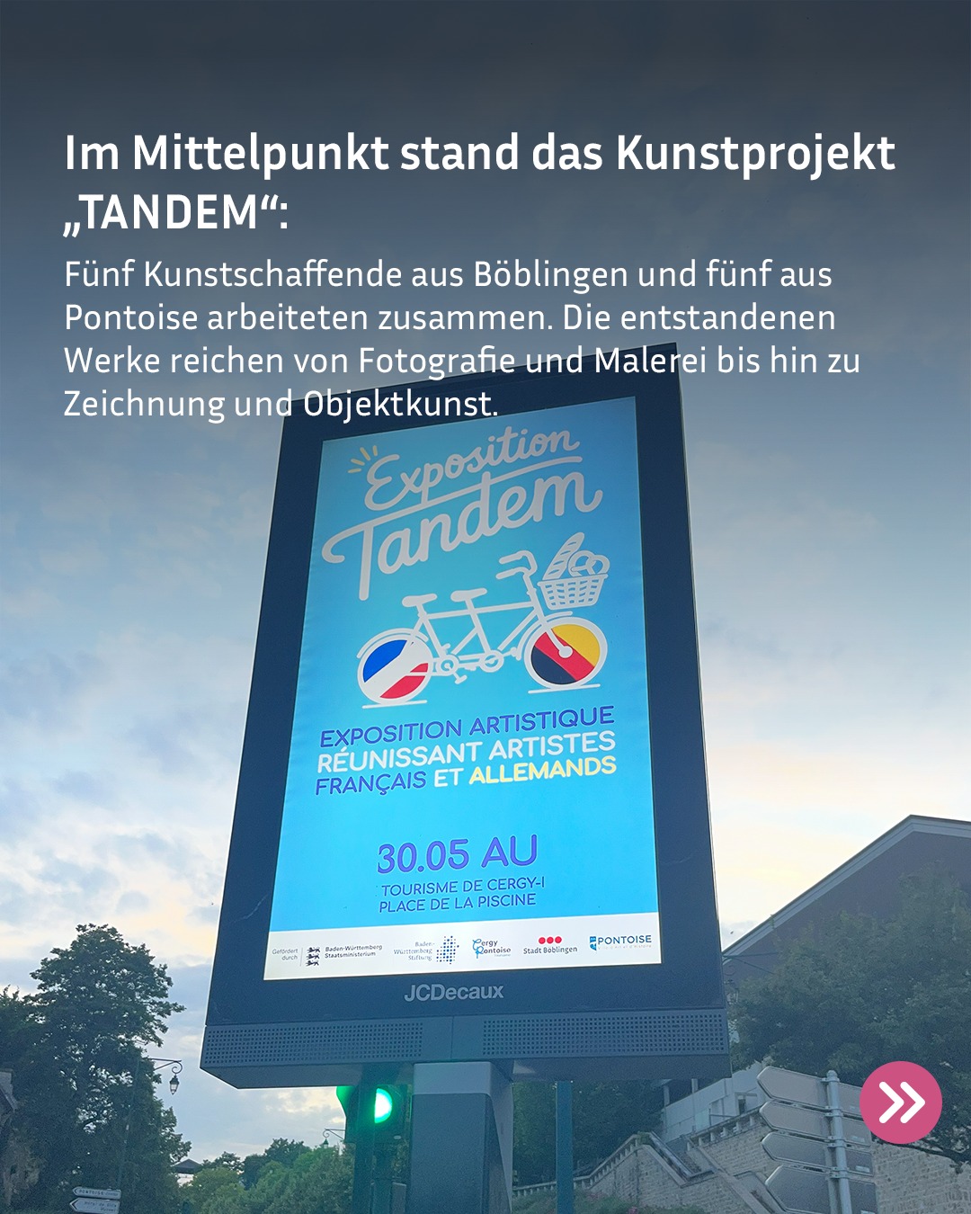 Ein digitales Werbeschild im Freien zeigt Werbung für die „Exposition Tandem“. Ein weißer Text-Overlay erläutert: „Im Mittelpunkt stand das Kunstprojekt ‚TANDEM‘: Fünf Kunstschaffende aus Böblingen und fünf aus Pontoise arbeiteten zusammen. Die entstandenen Werke reichen von Fotografie und Malerei bis hin zu Zeichnung und Objektkunst.“ Das Plakat selbst zeigt ein Tandemrad mit Rädern in den Farben der französischen und deutschen Flagge, den französischen Untertitel zur Zusammenkunft französischer und deutscher Künstler sowie das Datum 30.05. Am unteren Rand sind Logos von Förderern wie Baden-Württemberg und Pontoise zu sehen. (KI-Alternativtext)