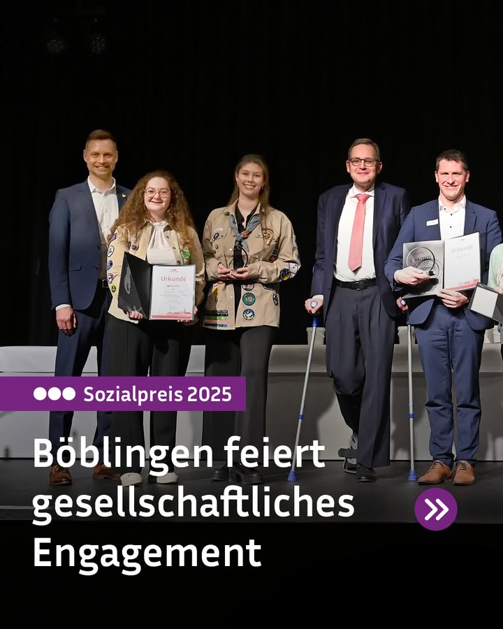 Dieser Alternativtext wurde KI-generiert: Eine Gruppe von Menschen steht auf einer Bühne und hält Auszeichnungen. Im Vordergrund befindet sich ein Schild mit der Aufschrift "Sozialpreis 2025".