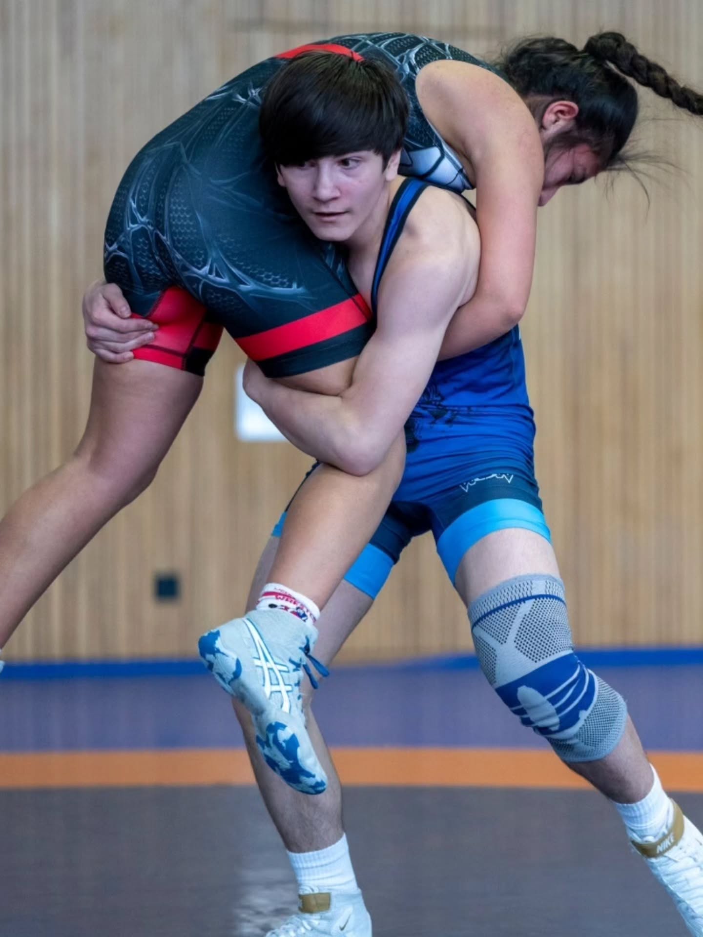 Dieser Alternativtext wurde KI-generiert: Zwei Personen sind in einem Ringkampf miteinander verbunden. Das Bild zeigt eine Nahaufnahme der Athleten in Aktion auf einer Matte.