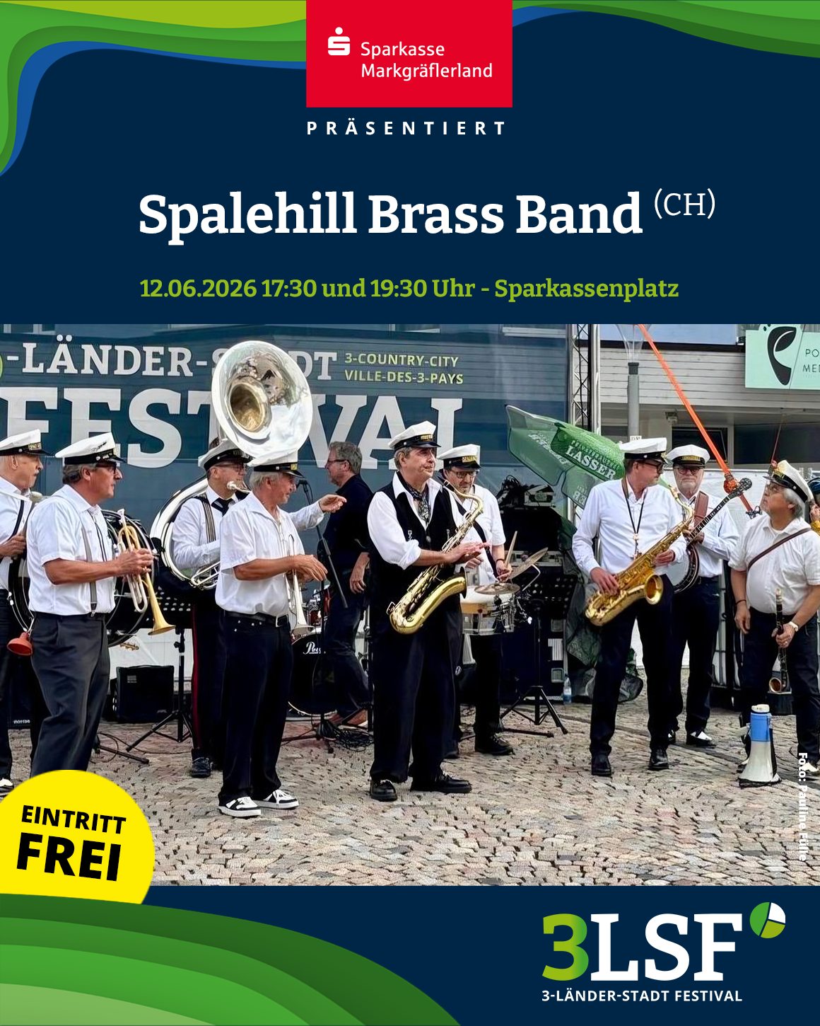 Dieser Alternativtext wurde KI-generiert: Ein Ensemble spielt auf Blechblasinstrumenten im Freien. Im Hintergrund sind Festivalbanner und Menschen zu sehen.