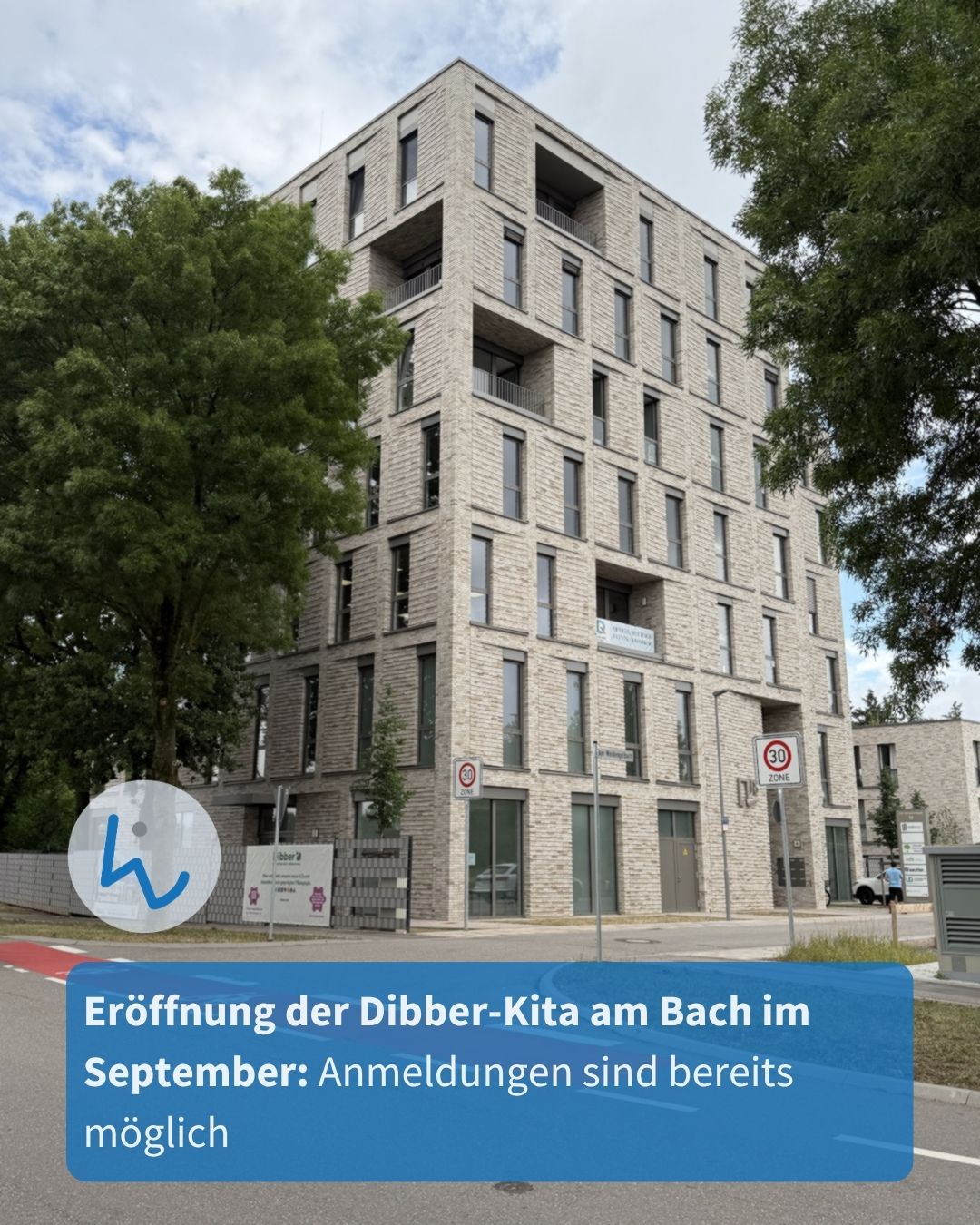 Ein modernes, mehrstöckiges Gebäude aus hellen Ziegelsteinen steht zwischen grünen Bäumen. Ein blauer Textkasten im Vordergrund informiert: "Eröffnung der Dibber-Kita am Bach im September: Anmeldungen sind bereits möglich". Links unten befindet sich ein Logo mit dem Buchstaben K. (KI-Alternativtext)