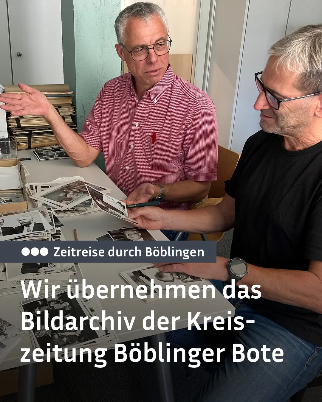 Zwei Männer sitzen an einem Tisch mit vielen alten Schwarz-Weiß-Fotografien. Der Mann links in der roten karierten Hemd gestikuliert mit der Hand und hält eine Fotografie, während der Mann rechts im schwarzen T-Shirt ebenfalls Fotografien und einen Stift betrachtet. Ein Text-Overlay lautet "Zeitreise durch Böblingen" sowie "Wir übernehmen das Bildarchiv der Kreiszeitung Böblinger Bote". (KI-Alternativtext)